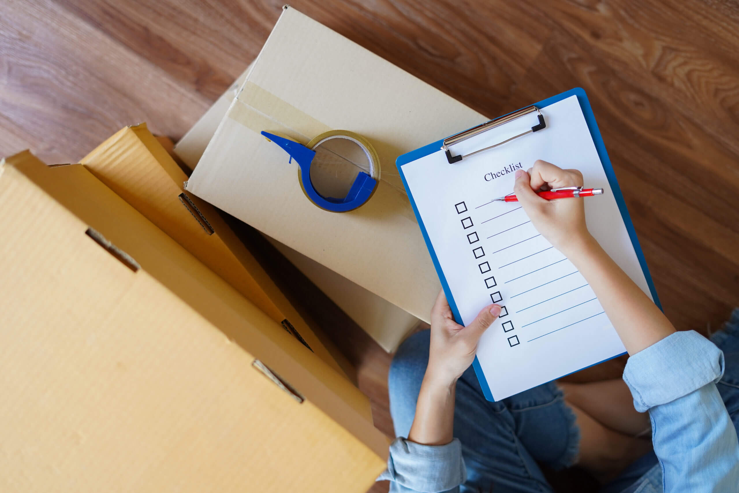 Top View of Woman with Clipboard and Moving Boxes | HouseMax